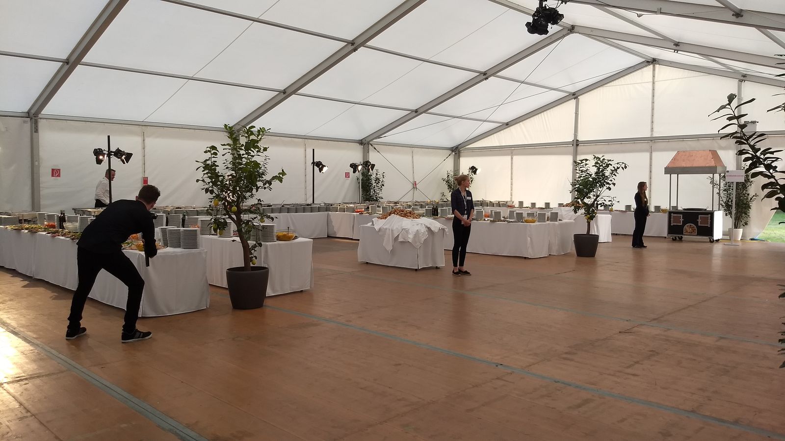 Buffet in einem großen Eventzelt mit Holzboden und Zitronenbäumchen